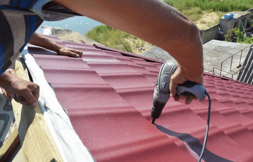 Roofer repairing a red roof
